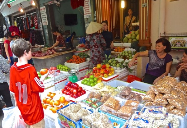 Alex haggles for an apple at the Hanoi street market.