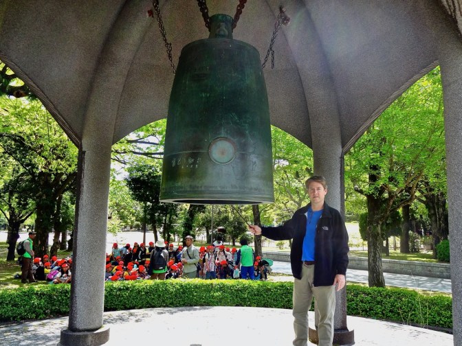 Kevin stands in front a large bell in the Hiroshima Peace Park.
