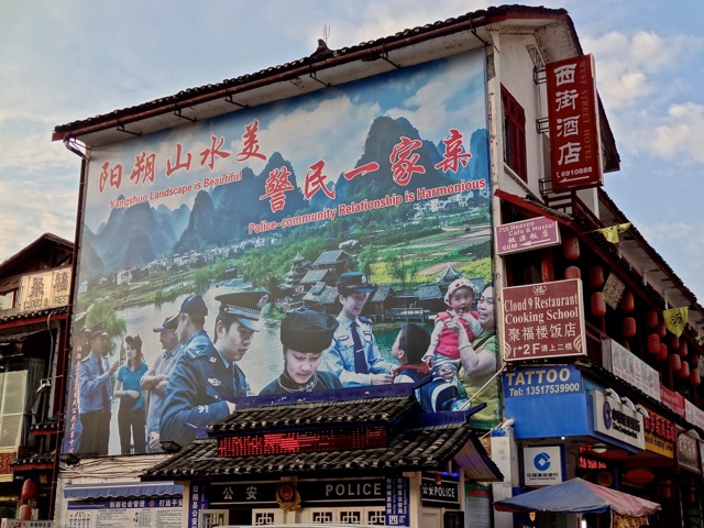"Police-Community Relationship is Harmonious". So says the huge sign on Yangshuo's West Street, just between Cloud 9 Restaurant and 7th Heaven Cafe above the tattoo shop.
