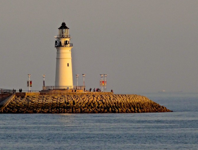 The last few minutes of the day's sun warm up the lighthouse at the end of the jetty near Qingdao's Olympic Sailing Center-the sailing home of the 2008 Summer Olympics.
