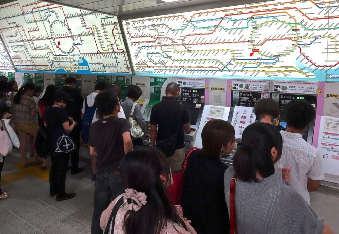 Commuters stand in quay to buy tickets for the Tokyo subway and the long distance trains that run in and out of the world's busiest train station.  Maps of the train system in Tokyo have been compared to dropping a large bowel of colored linguini on a piece of paper.