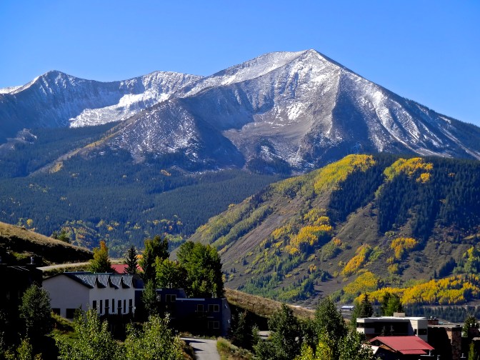 Snow, early and temporary in late September,  dusts the peaks on and around Crested Butte. The last of the annual golden canopy of aspen leaves glow in the warmer valleys below.